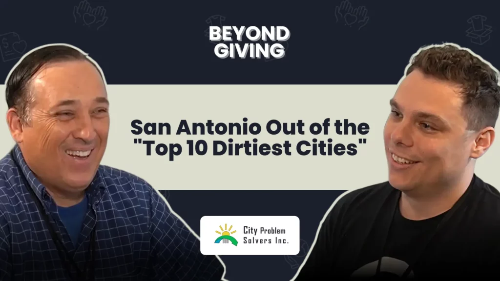 An episode cover image featuring two men smiling and facing each other against a dark background with light-colored graphics. The man on the left wears a blue plaid shirt, and the man on the right wears a black shirt. Bold text in the center reads, "San Antonio Out of the 'Top 10 Dirtiest Cities'". The top of the image features the branding "BEYOND GIVING", and the bottom center displays a white logo for "City Problem Solvers Inc." featuring a green and yellow sun graphic.